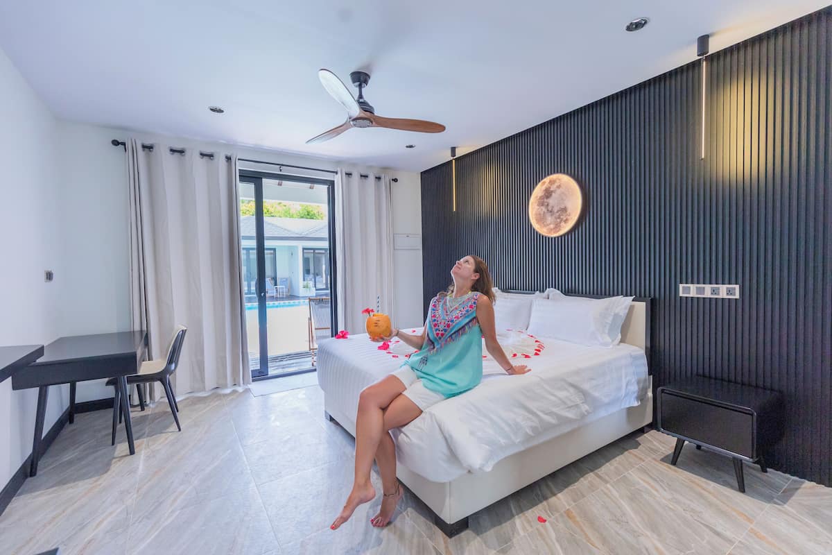 A modern hotel room with a bed, a desk, and a chair.