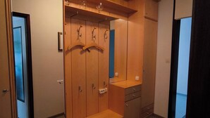 Un vestidor con puertas de madera, un espejo y una barra para colgar ropa.