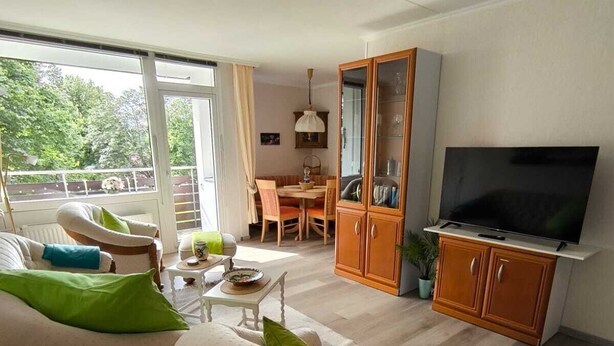 Una sala de estar con un sofá, una mesa de comedor y un televisor.