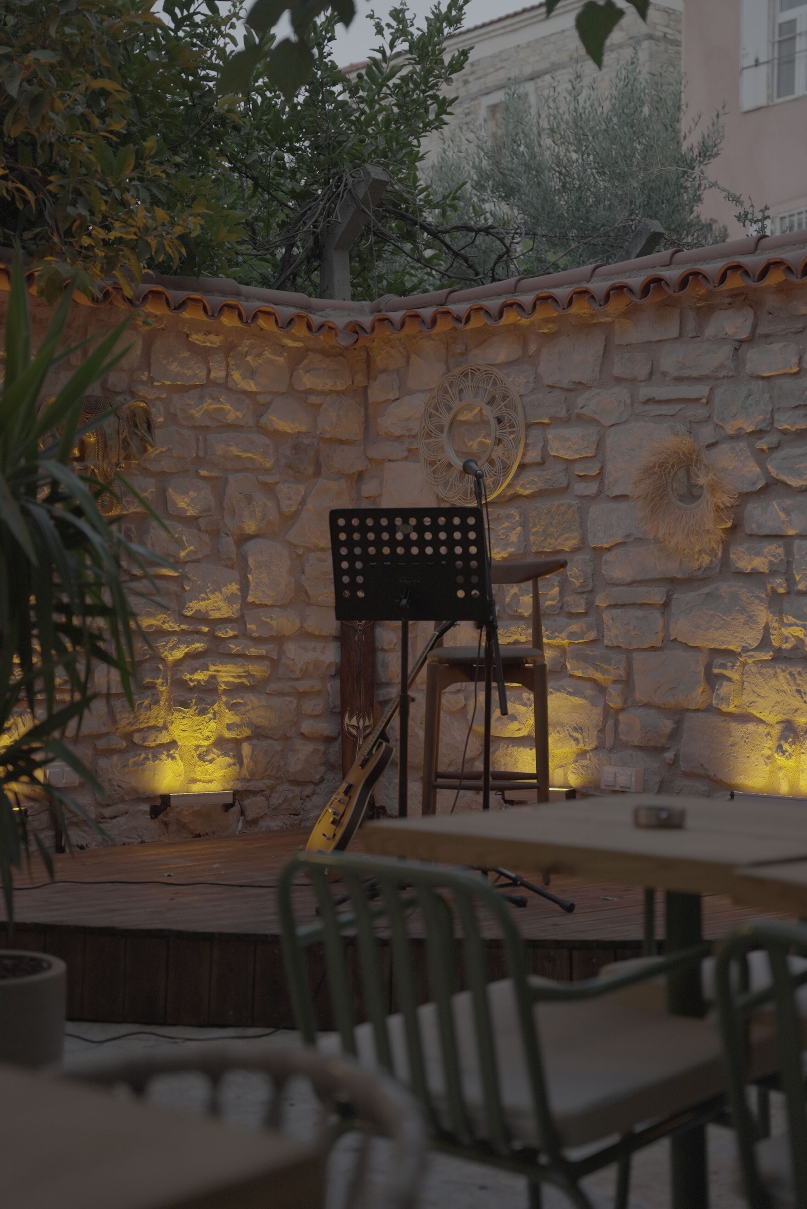 A stone wall with a rustic outdoor seating area, including a table and chairs.