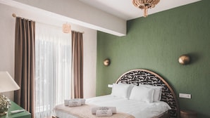 A bedroom with a bed, curtains, a lamp, and a green wall. - Pietra Social House (Urla)