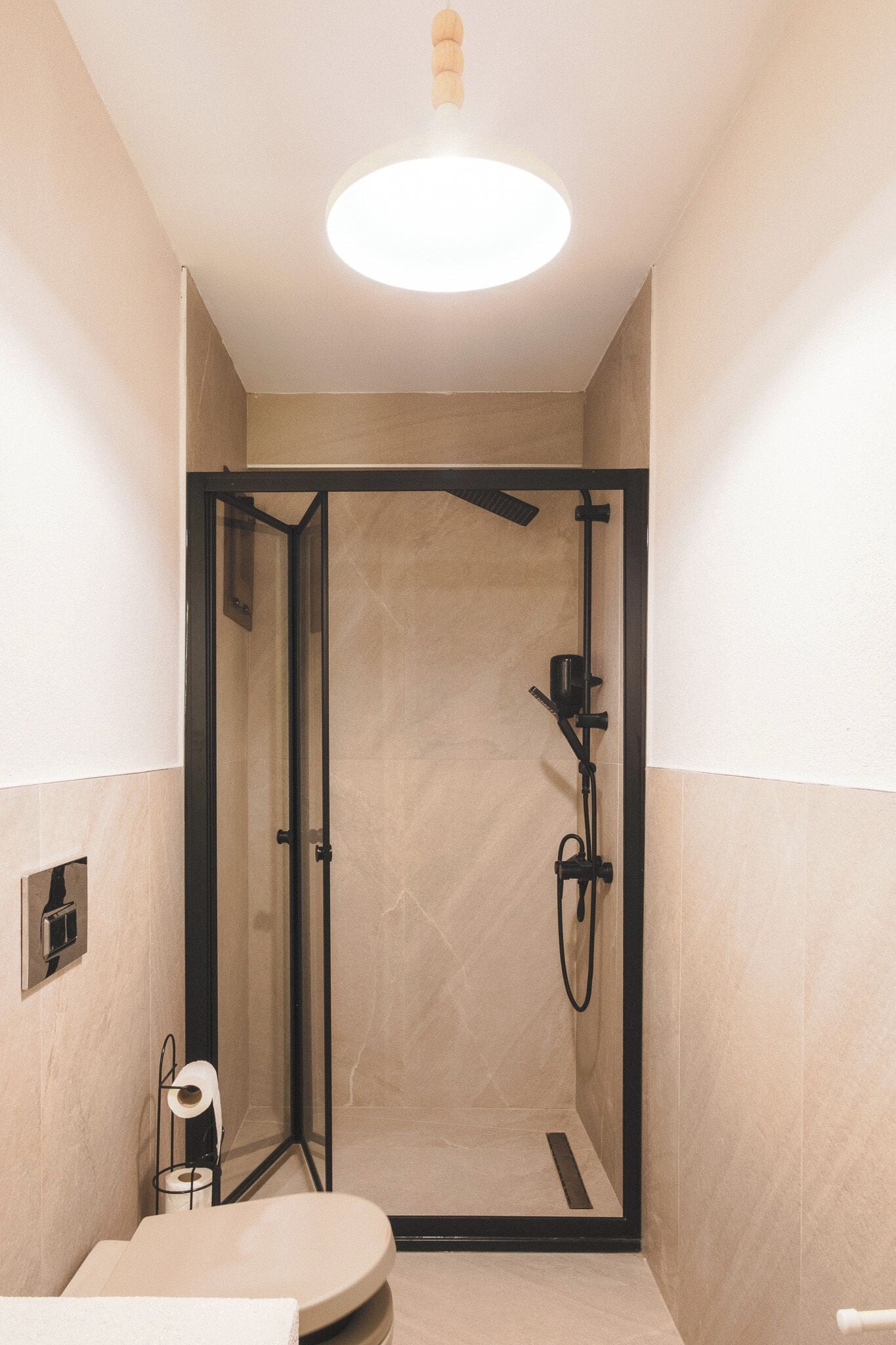 Un baño moderno con ducha de vidrio, inodoro y lavamanos.