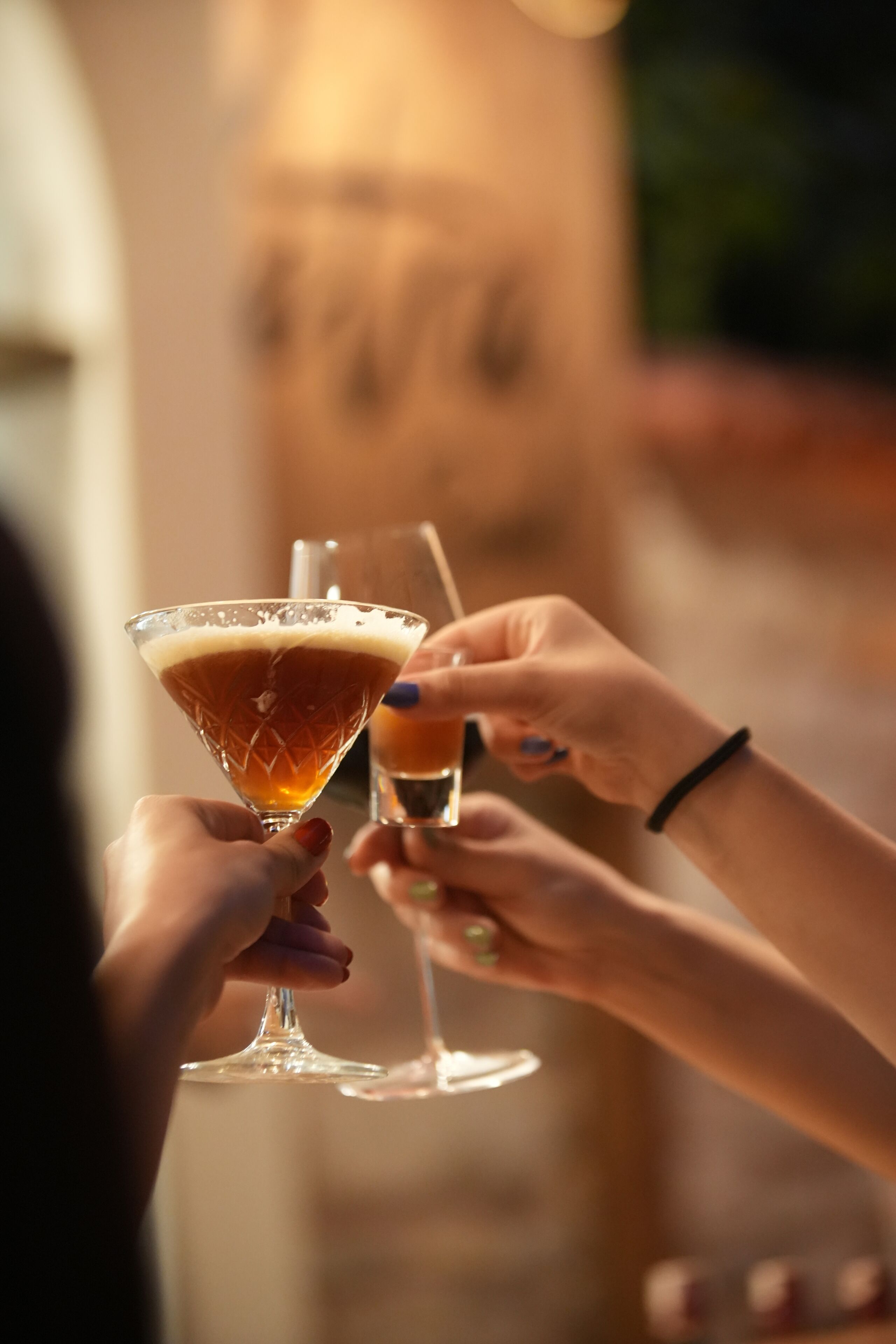 Deux personnes tenant des verres à cocktail.