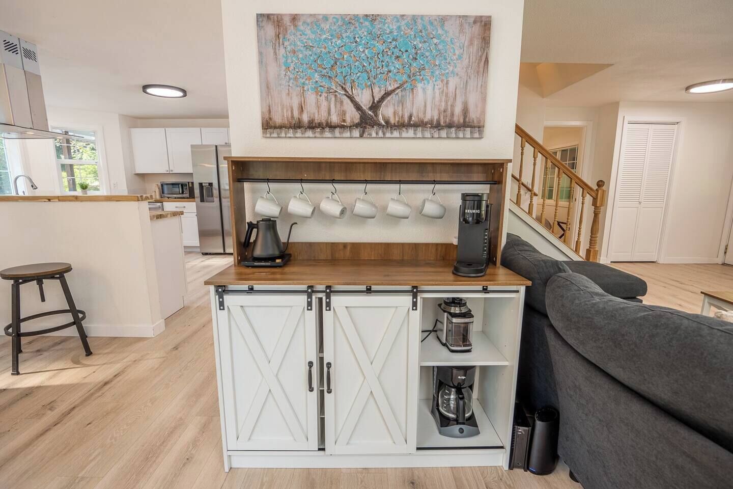A modern kitchen with a central island, a coffee machine, and a kettle.