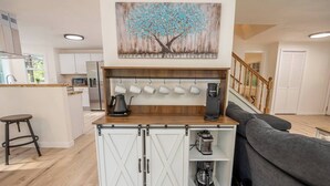 A modern kitchen with a central island, a coffee machine, and a kettle. - Updated Large River Front Home with Hot Tub (McKenzie Bridge)