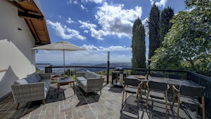 A patio with wicker furniture, a grill, and a view of the sea. - Soothing villa with with private pool, seasonally heated; pet friendly (Villanuova sul Clisi)