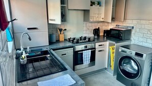 A modern kitchen with a built-in oven, microwave, and washing machine.