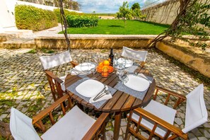 Enjoy al fresco dining on a beautifully set patio with a lush lawn view.