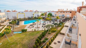 A residential building with a swimming pool, outdoor seating, and a well-maintained garden.