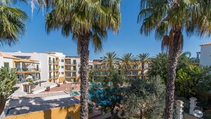 Ein Resort mit mehrstöckigen Gebäuden, einem Schwimmbad und Palmen.