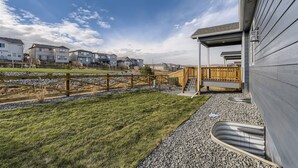 Un quartier résidentiel avec des maisons, une clôture en bois et un chemin de gravier.