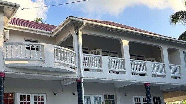 A two-story house with a swimming pool in the foreground. - Poolside Suites 5-Mins from the Beach w/ AC & Wi-Fi (Rodney Bay)