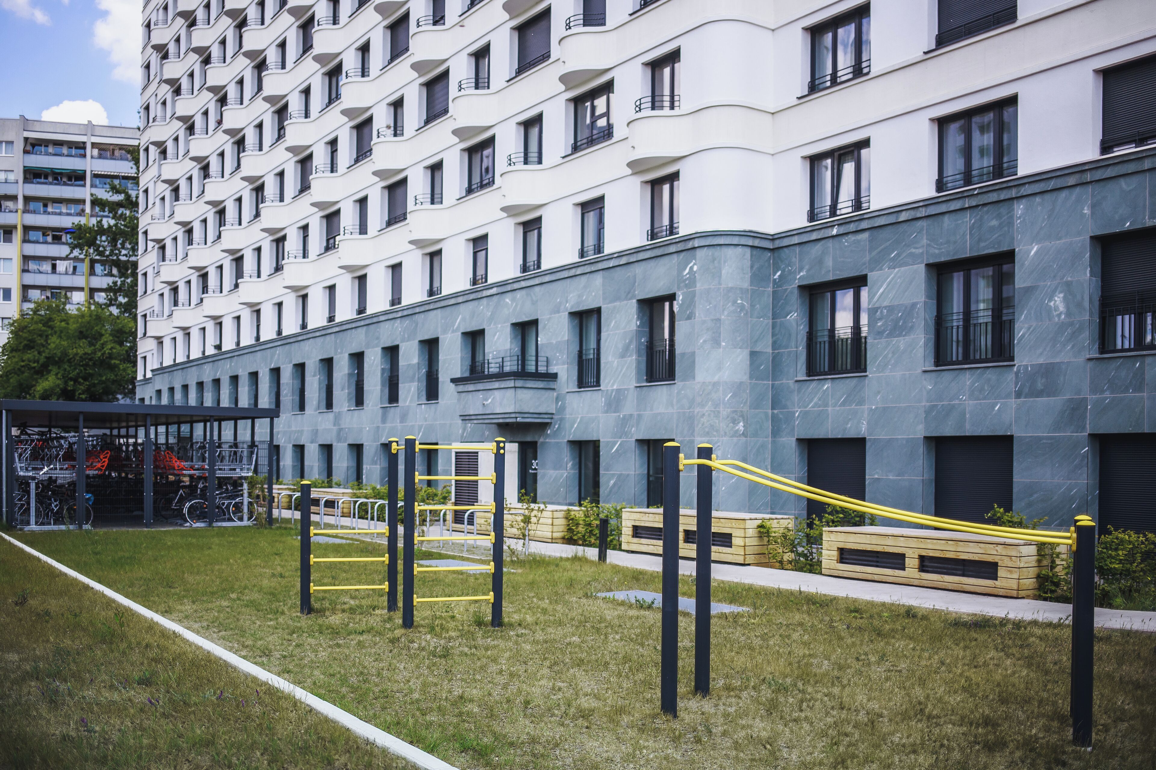 Un edificio moderno con un cortile interno dotato di attrezzature per esercizi all'aperto.