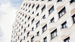 A multi-story building with a repeating pattern of balconies and windows. - The Circus Living (Berlin)