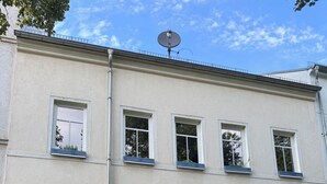A multi-story building with a blue door and numbered windows. - Loft mit Privater Dachterrasse (Gera)