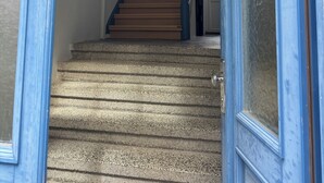 A staircase with blue-framed doors, a wooden handrail, and a hanging pendant light. - Loft mit Privater Dachterrasse (Gera)