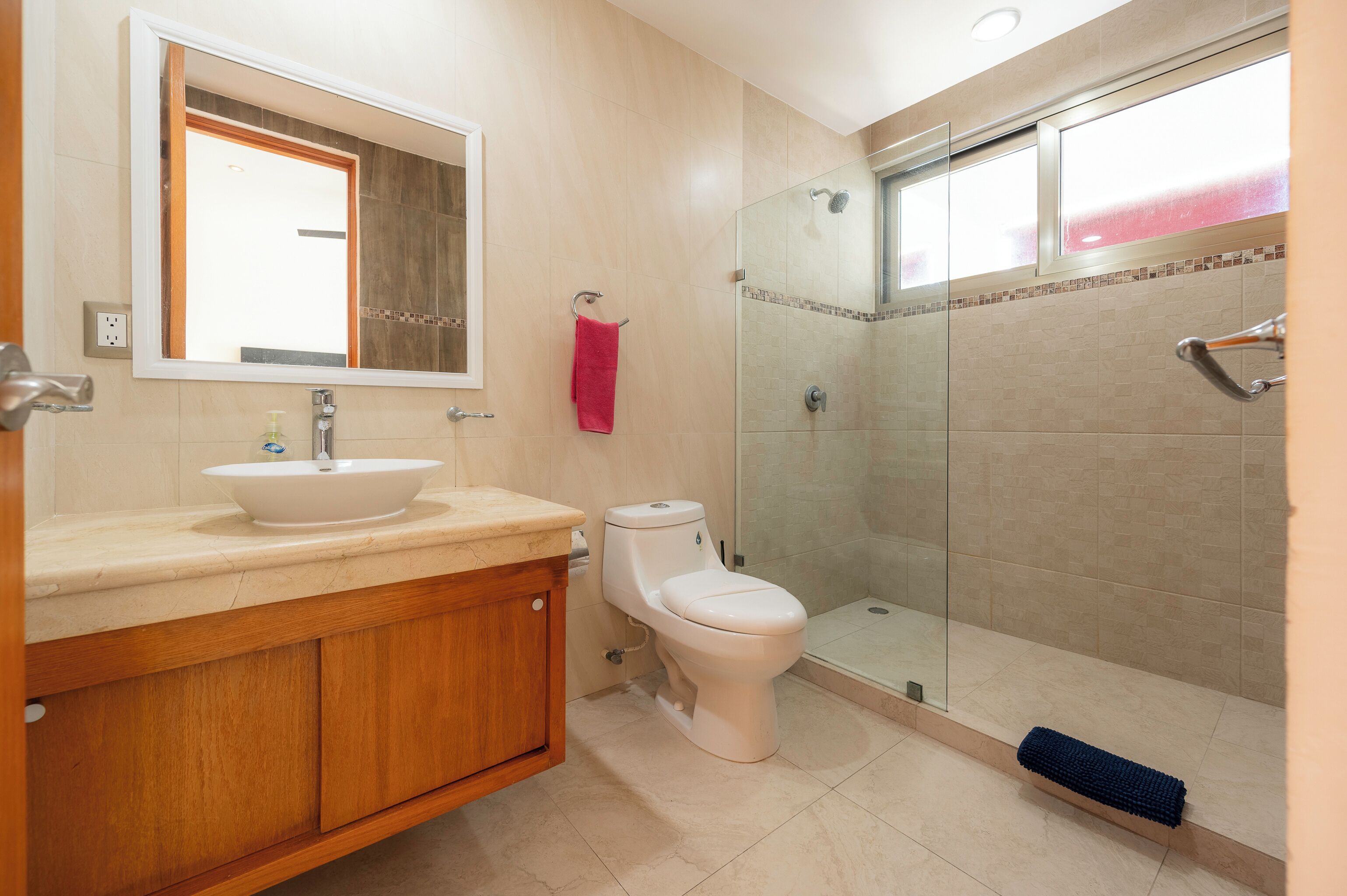 Une salle de bain équipée d’un lavabo, de toilettes et d’une douche à parois en verre.