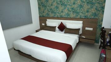 A neatly made bed with white and red bedding, a wooden headboard, and a wall with a textured pattern.