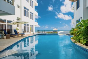 Een buitenzwembad, parasols bij het zwembad en ligstoelen