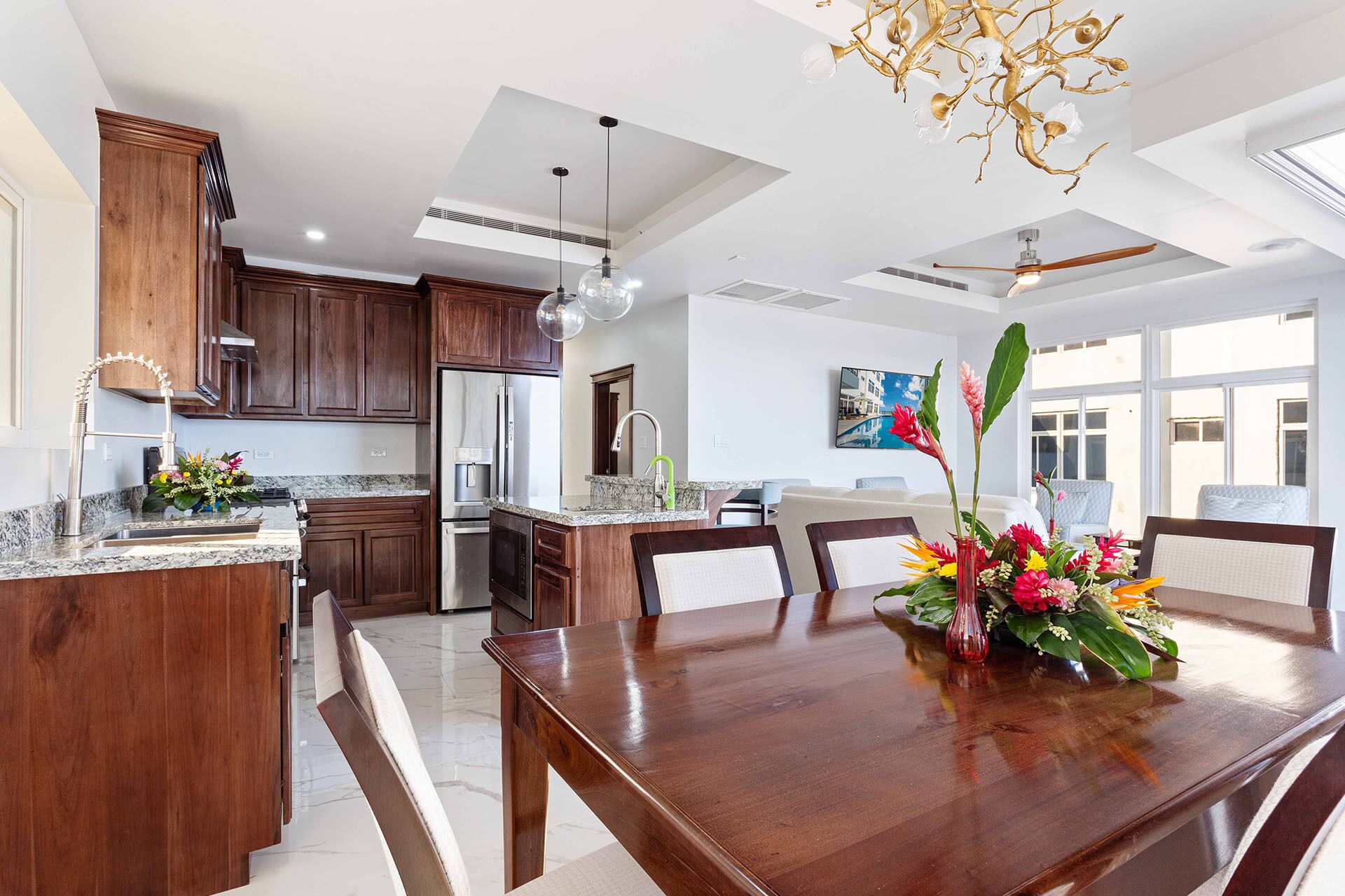 Una cocina moderna con armarios de madera oscura, electrodomésticos de acero inoxidable y encimera de granito.