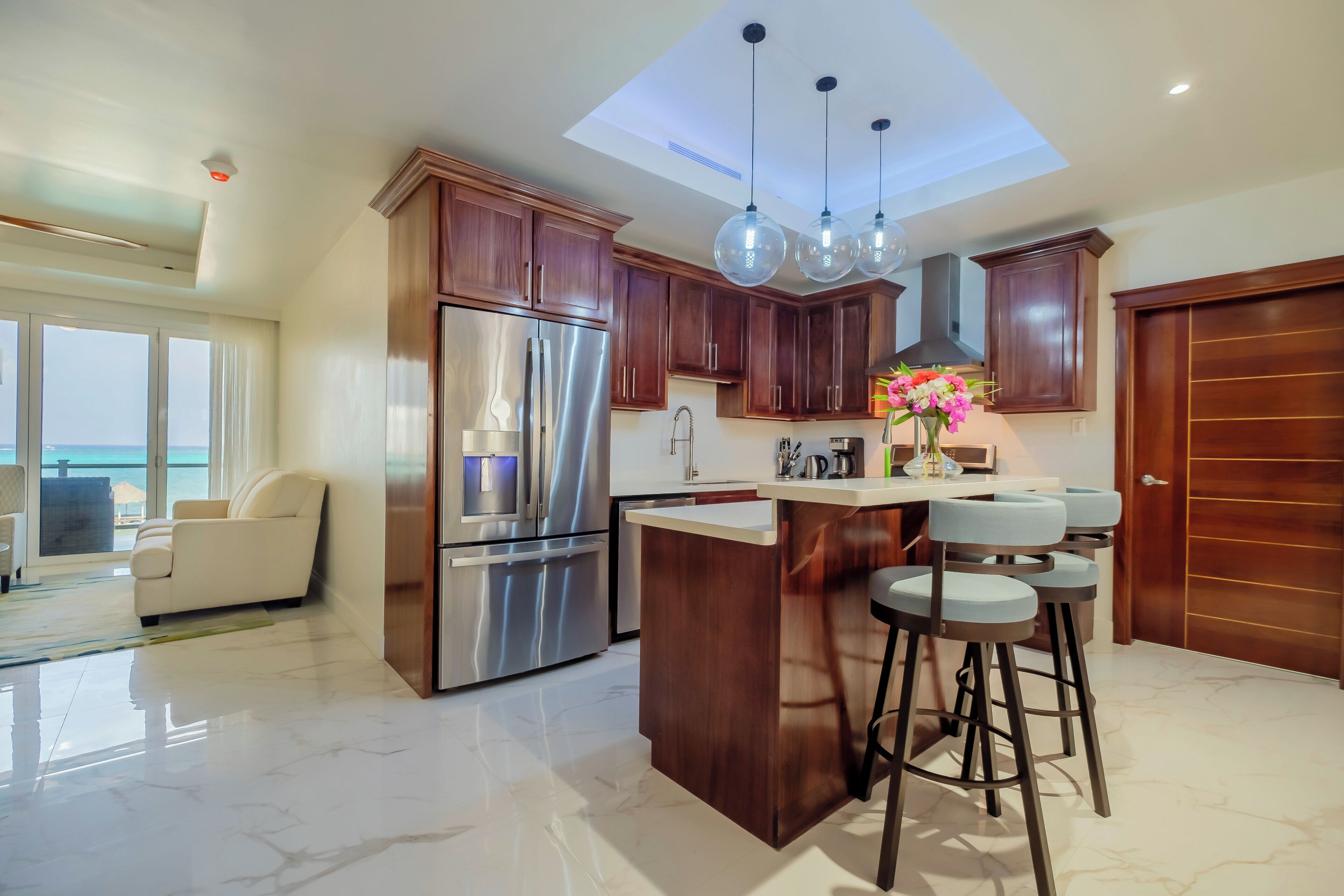 Una cocina moderna con una isla central, electrodomésticos de acero inoxidable y armarios de madera.