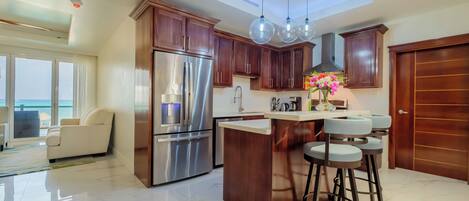 Una cocina moderna con una isla central, electrodomésticos de acero inoxidable y armarios de madera.