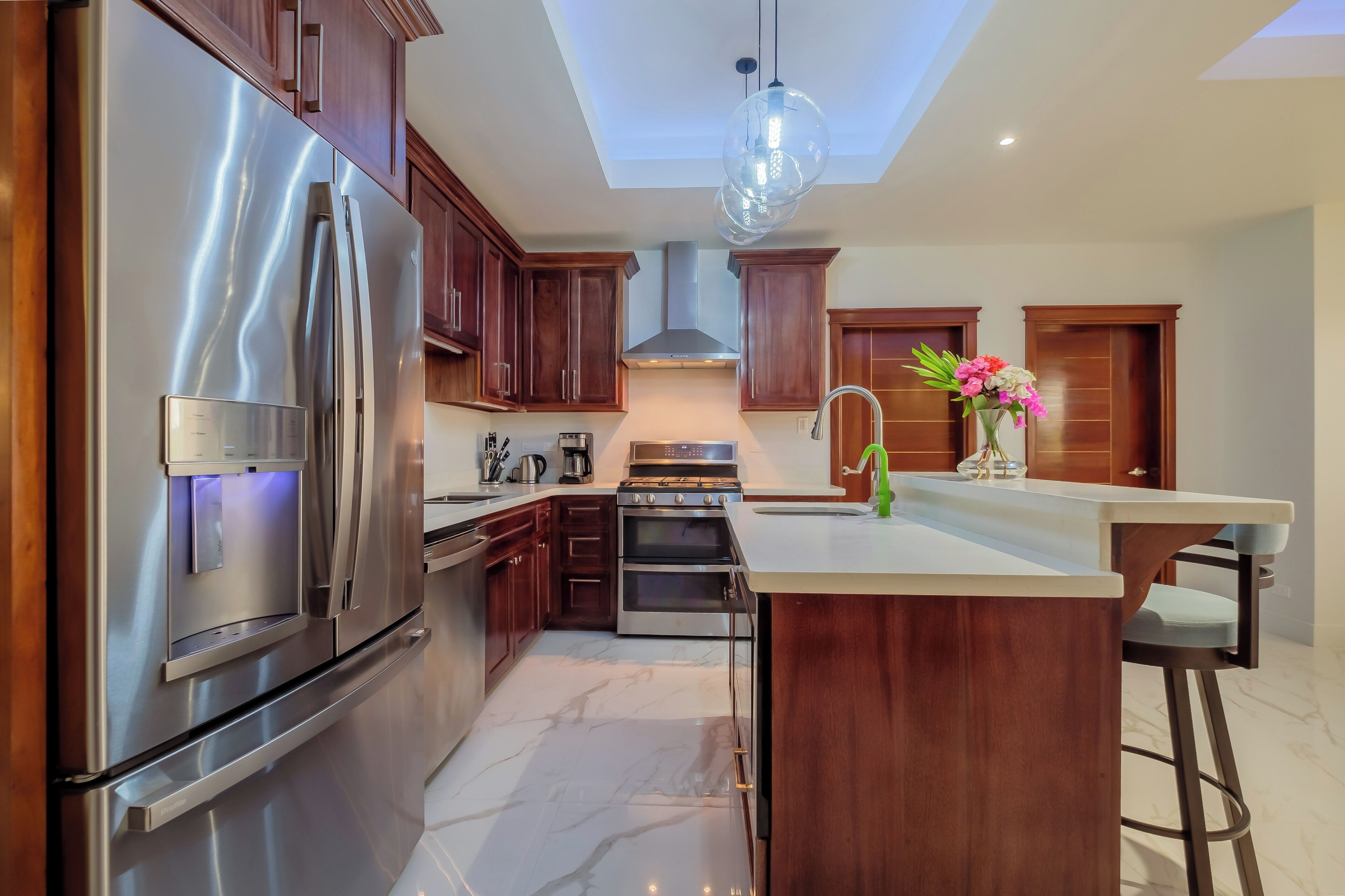 A modern kitchen with stainless steel appliances, wooden cabinets, and a central island.