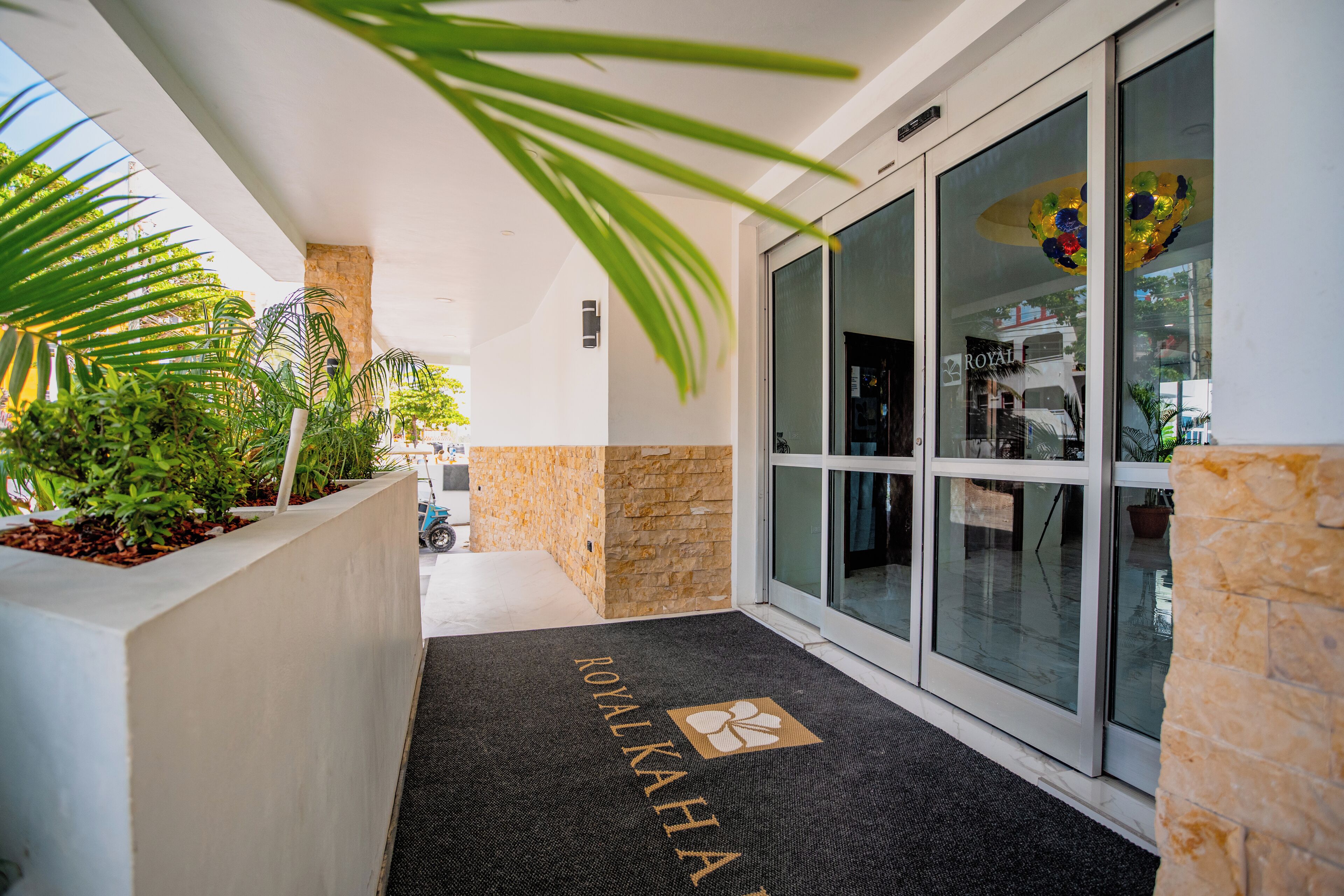 A hotel entrance with a black mat reading "ROYAL KAHIA" and a glass door.