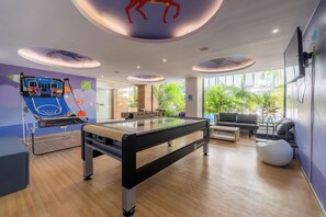 Relax and unwind in our modern recreational area, featuring a foosball table, pool table, and comfortable seating for lounging.