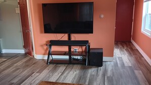 A living room with a wooden coffee table, a TV on a stand, and a wooden floor.