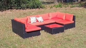 Un sofá modular con cojines en un jardín.