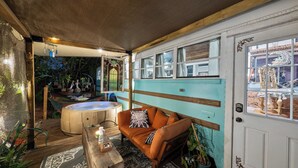 A cozy room with a wooden ceiling, a teal wall, a brown leather sofa, a wooden coffee table, and a white door.