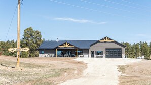 A building with a garage, a covered patio, and a sign that reads "This must be the place."