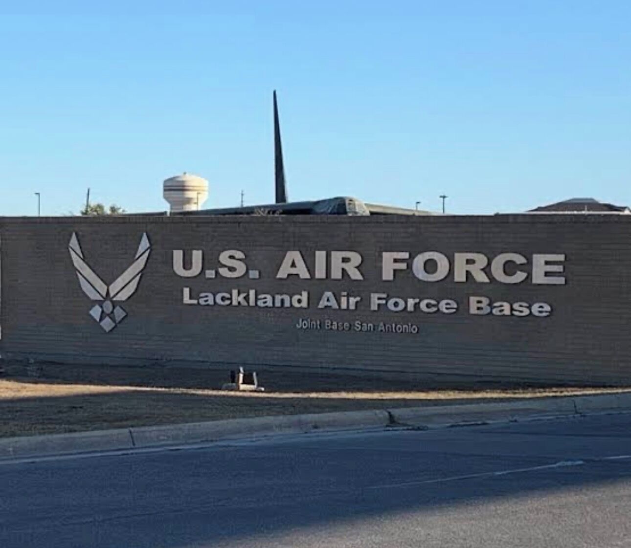 A U.S. Air Force base sign with a winged emblem and the text 'U.S. AIR FORCE Lackland Air Force Base Joint Base San Antonio'.
