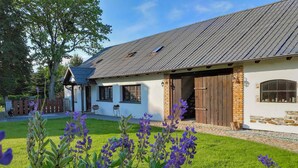 A rustic house with a sloped roof, a brick chimney, and a wooden door. - Amazing apartment in Huta Gorna with WiFi (Huta Gorna)