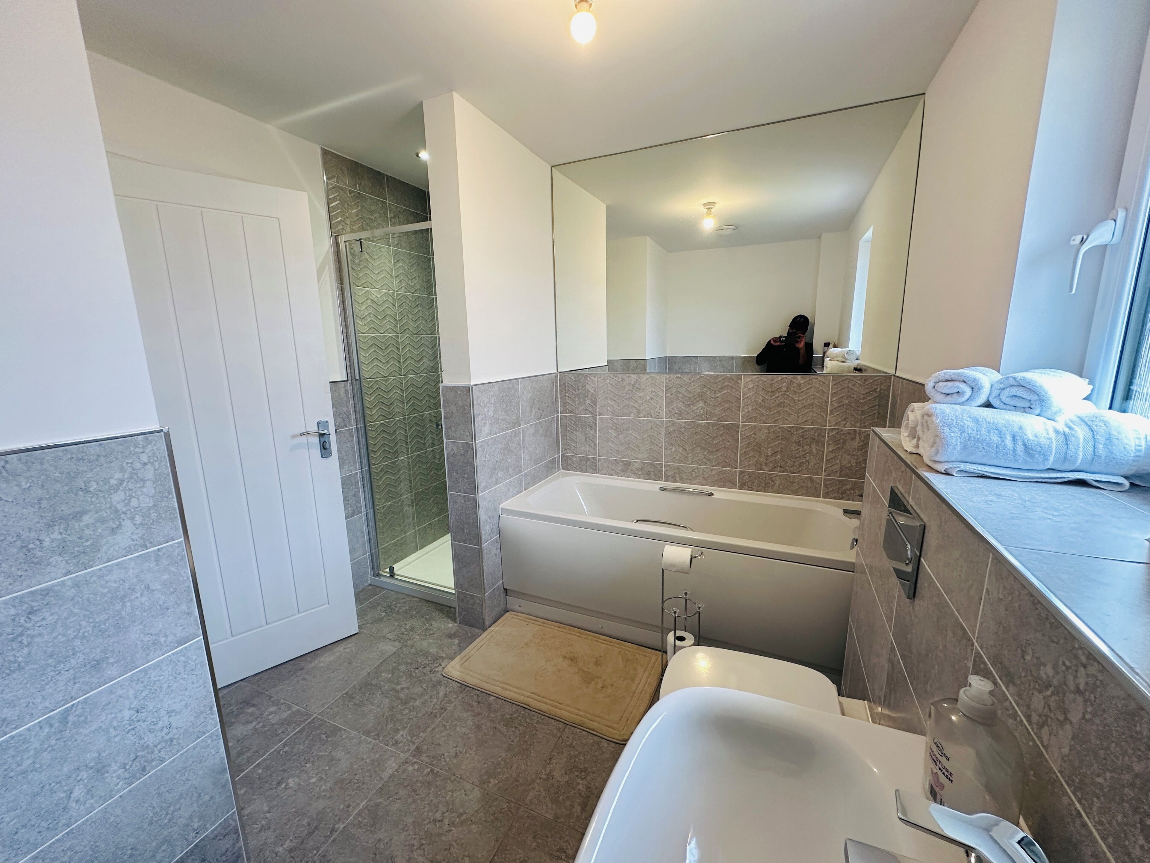 Ein modernes Badezimmer mit Badewanne, Dusche und Toilette.