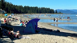 A beach with tents and people. - Moon shell Cottage-a relaxing cozy retreat for all seasons. (Parksville)