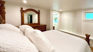 A bedroom with two beds, a wooden dresser, a large mirror, and a window. - Family-friendly, Uptown New Orleans retreat, 4 blocks from St. Charles.  (New Orleans)