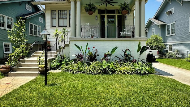 A two-story house with a porch, columns, and a sign above the entrance. - Family-friendly, Uptown New Orleans retreat, 4 blocks from St. Charles.  (New Orleans)