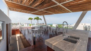 A rooftop terrace with a wooden pergola, outdoor seating, and a kitchen area with a sink. - Paradise found. Unique apartment in Playa del Carmen for you (Playa del Carmen)