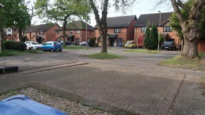 A residential street with houses, parked cars, and a paved driveway. - Spacious Home from Home! Perfect for Farnborough Airshow.  (Farnborough)