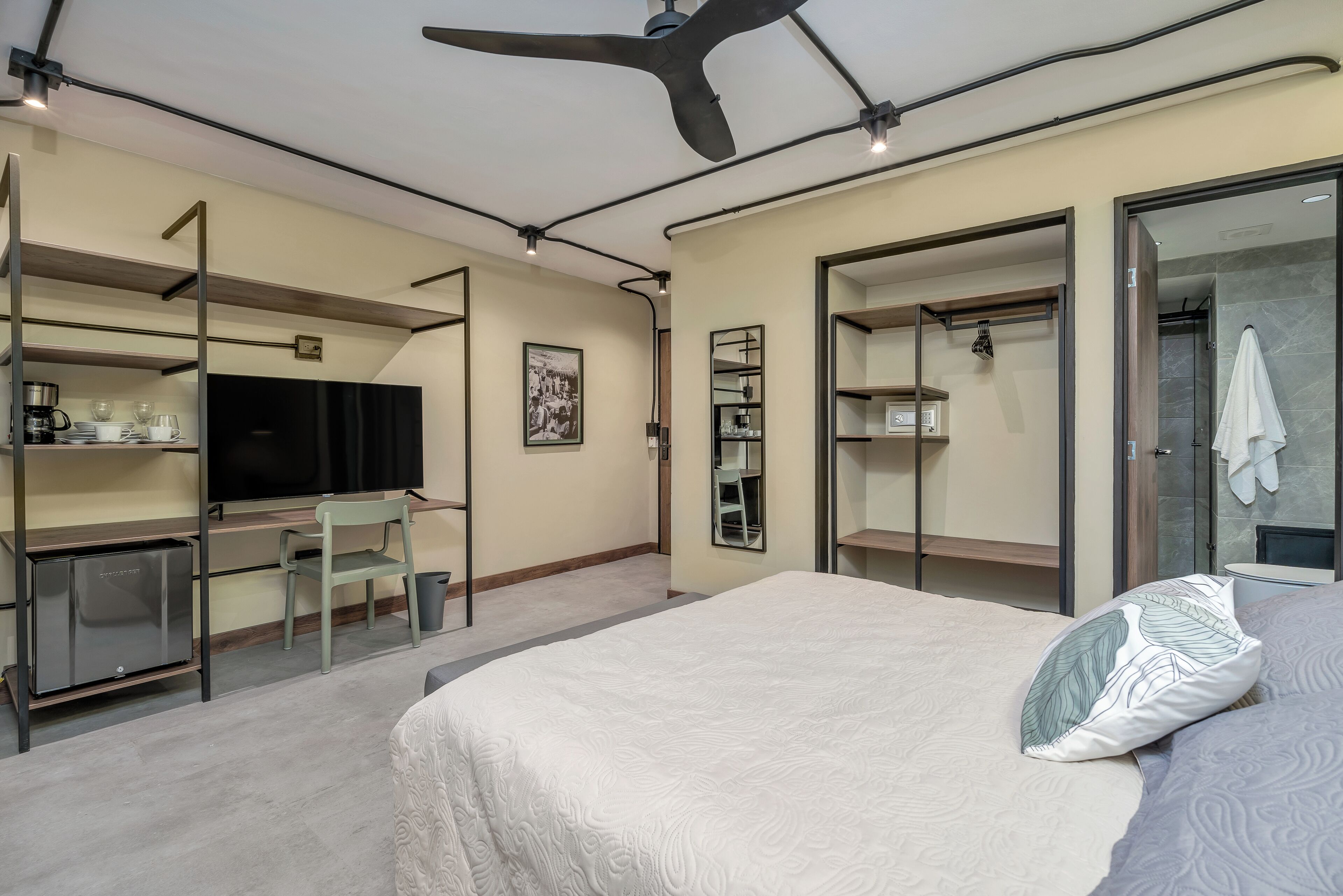 Ein modernes Schlafzimmer mit Bett, Schreibtisch, Stuhl und Kleiderschrank.