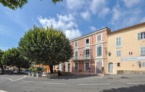 Stroll through the charming streets of this European town, surrounded by a classical building and a picturesque tree.