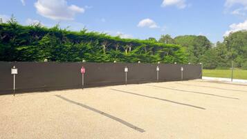 A parking area with a black fence and multiple parking signs.