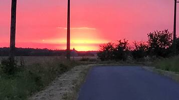 A rural road with a sunset in the background.