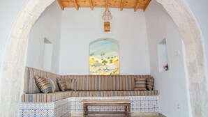 Un rincón acogedor con un banco acolchado, una pequeña mesa de madera y una lámpara colgante decorativa.