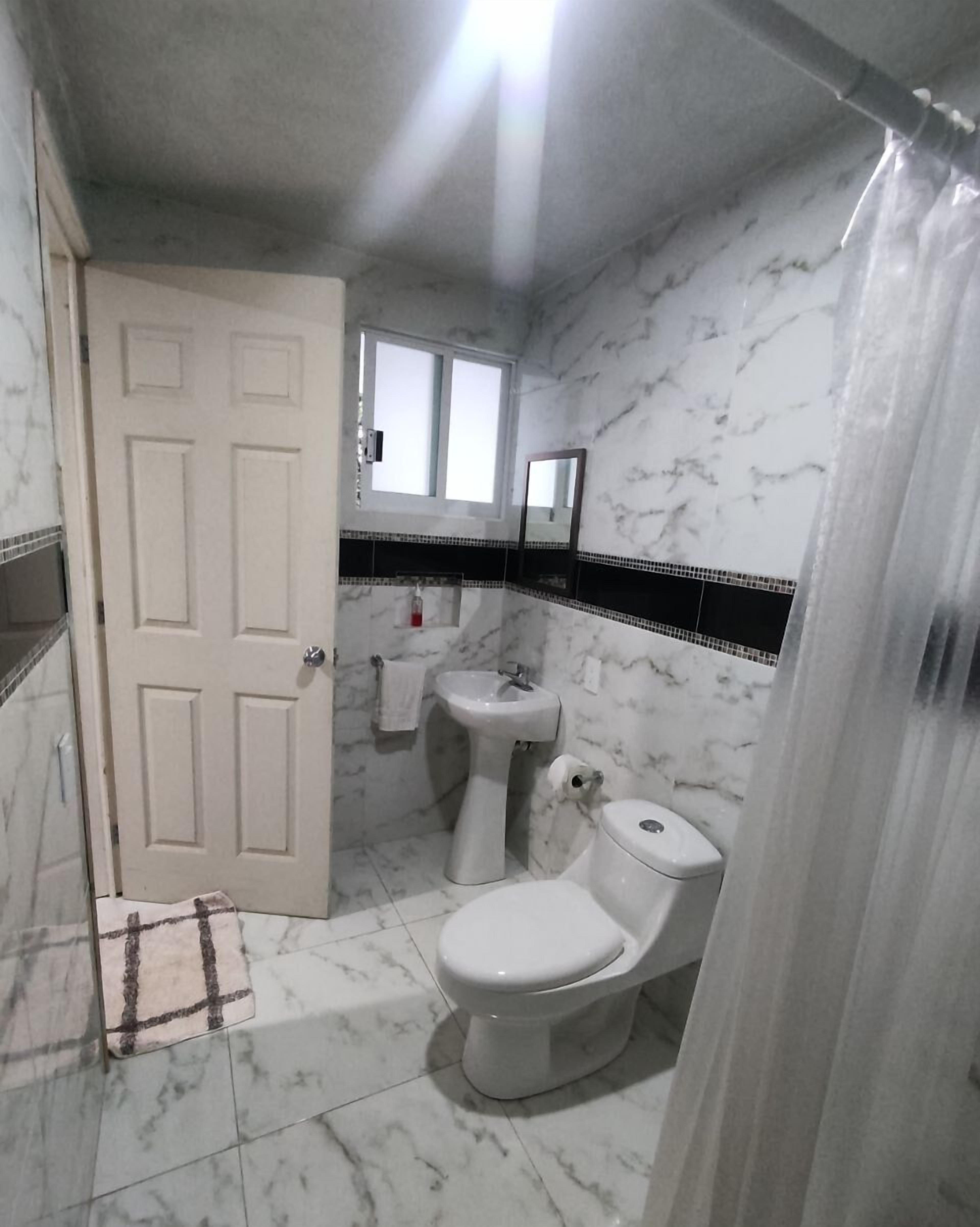 Un baño con inodoro, lavabo y espejo.