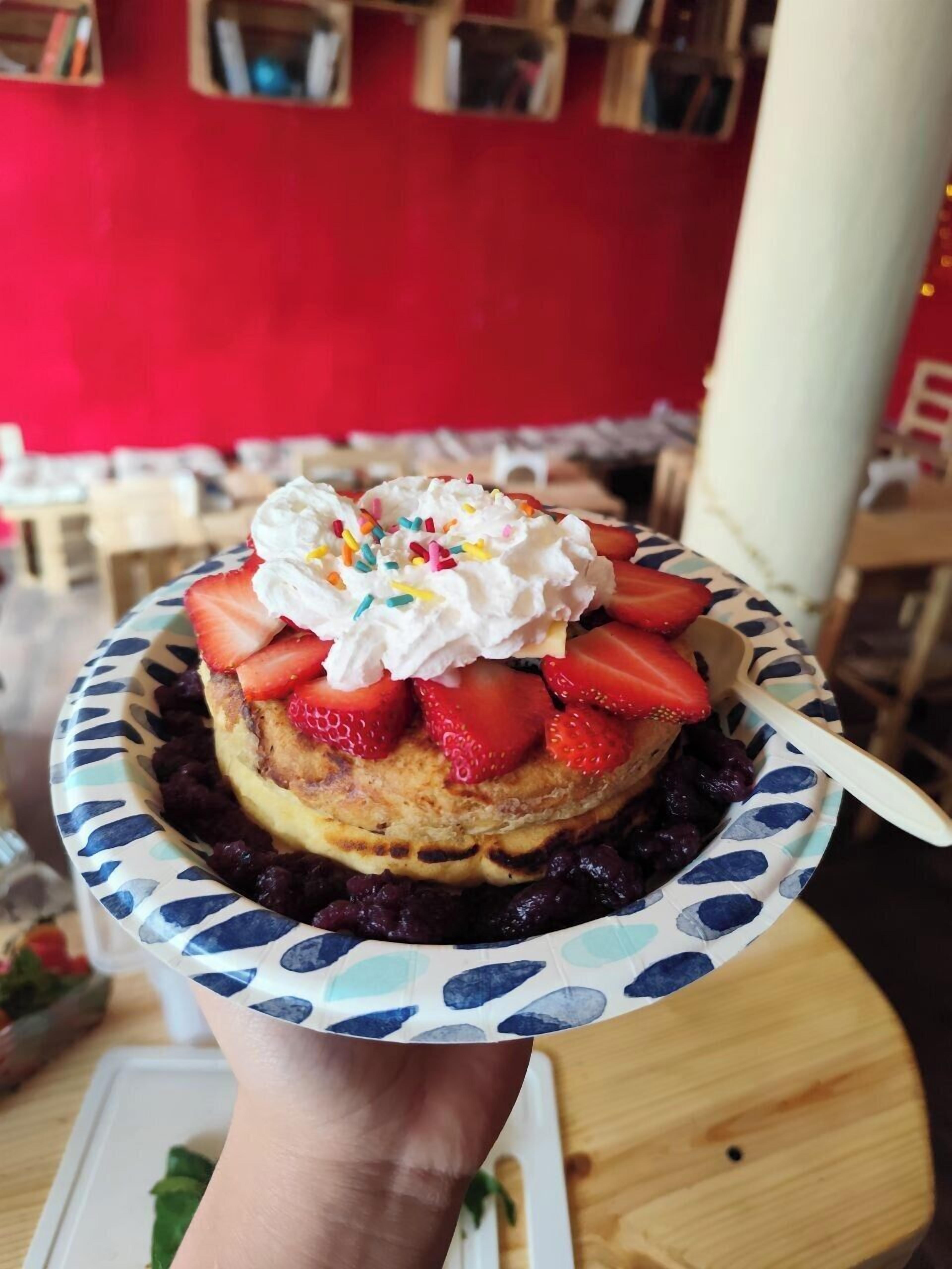 Un dessert aux fraises, accompagné de crème fouettée, présenté dans une assiette.