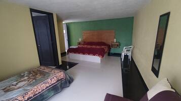 A bedroom with a bed, bedside tables, a chair, and a mirror.