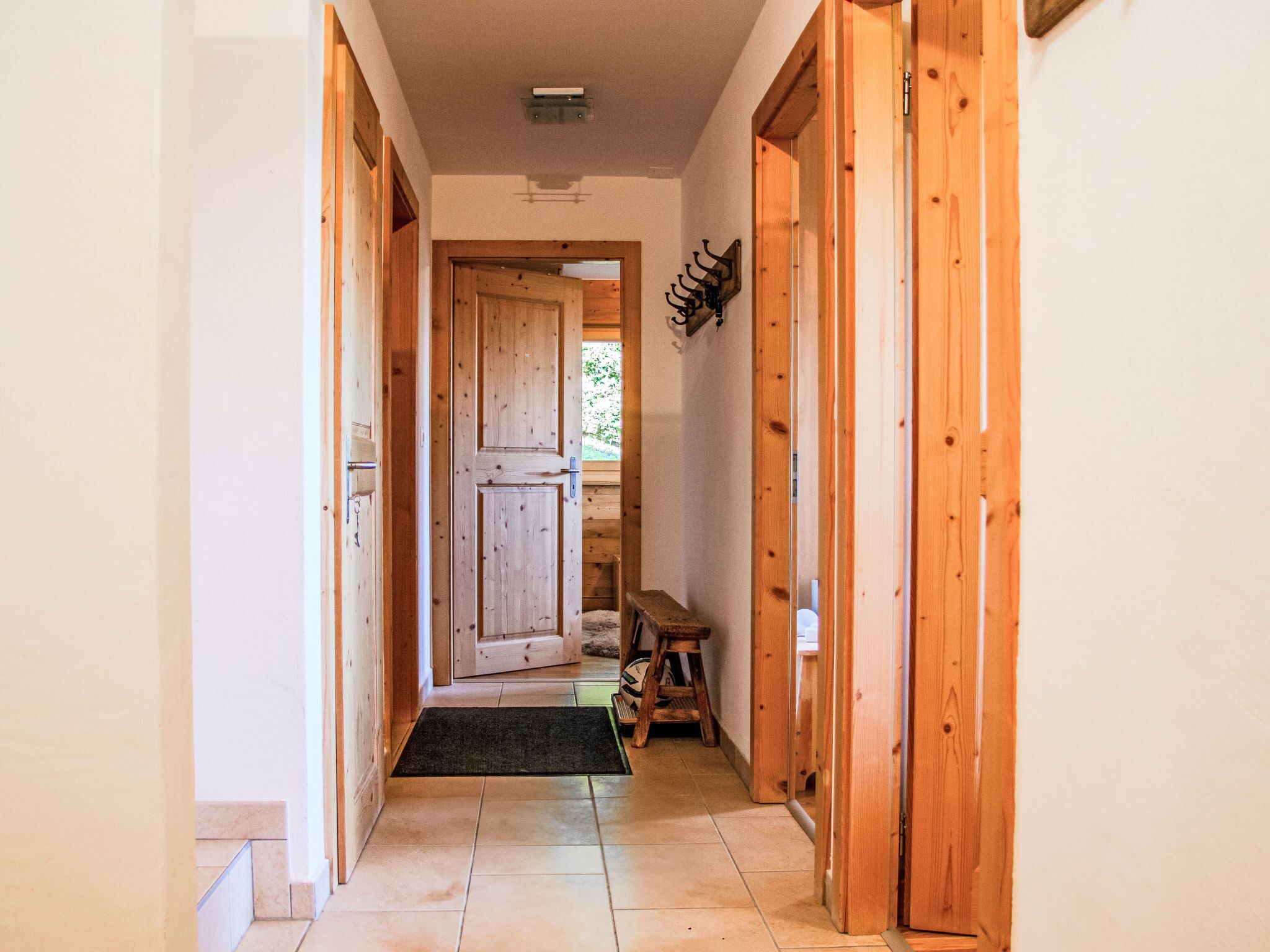 Un couloir en bois avec une porte donnant sur une pièce.